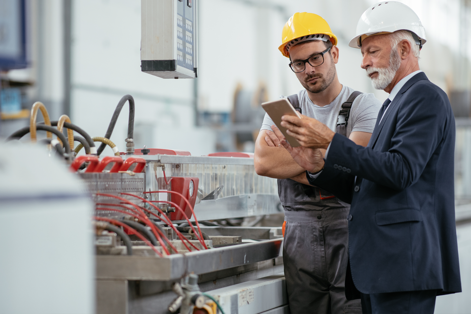 Senior engineers reviewing technical drawings on an industrial site